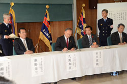 写真：協定書にサインをする久野市長