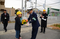 写真：日ごろの感謝をこめて警察官の大野さんに花束を贈る