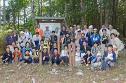 【写真】参加者と指導者全員で森林の中で記念撮影