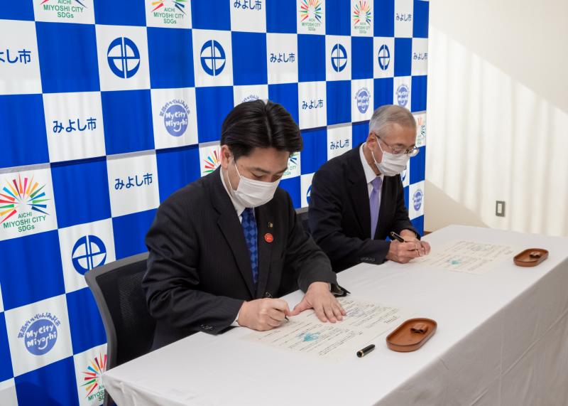 協定書に署名する小山市長と吉川社長