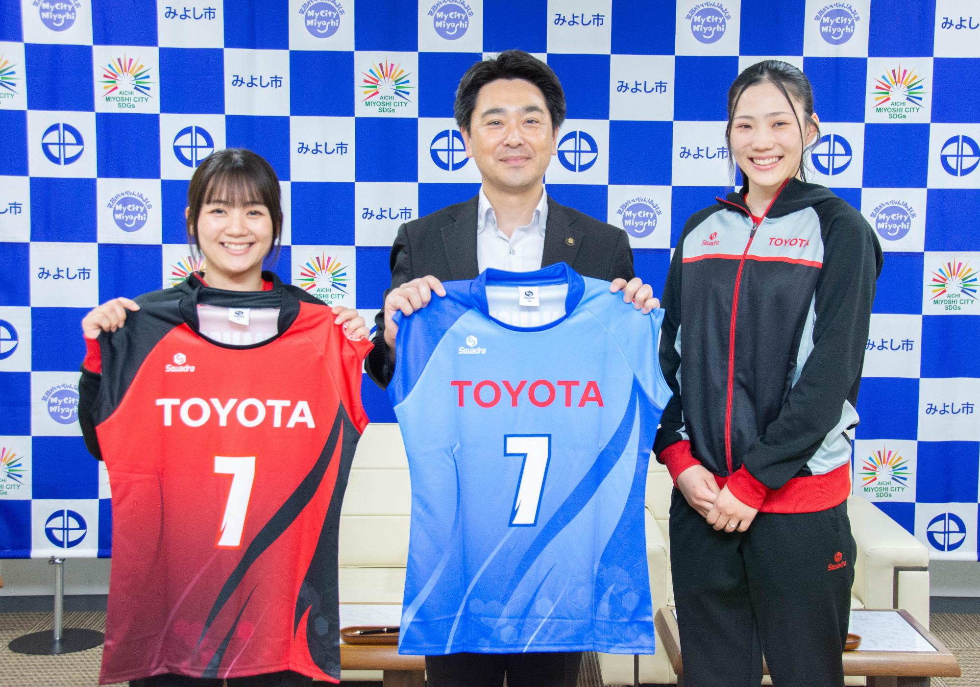 ユニフォームを手に記念写真