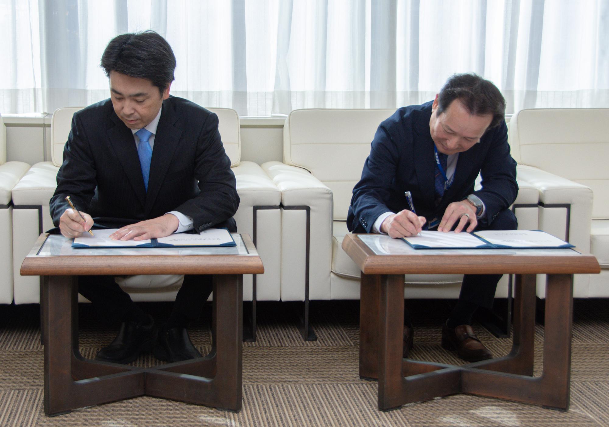 調印する小山市長とカネヨシの鈴木代表取締役社長