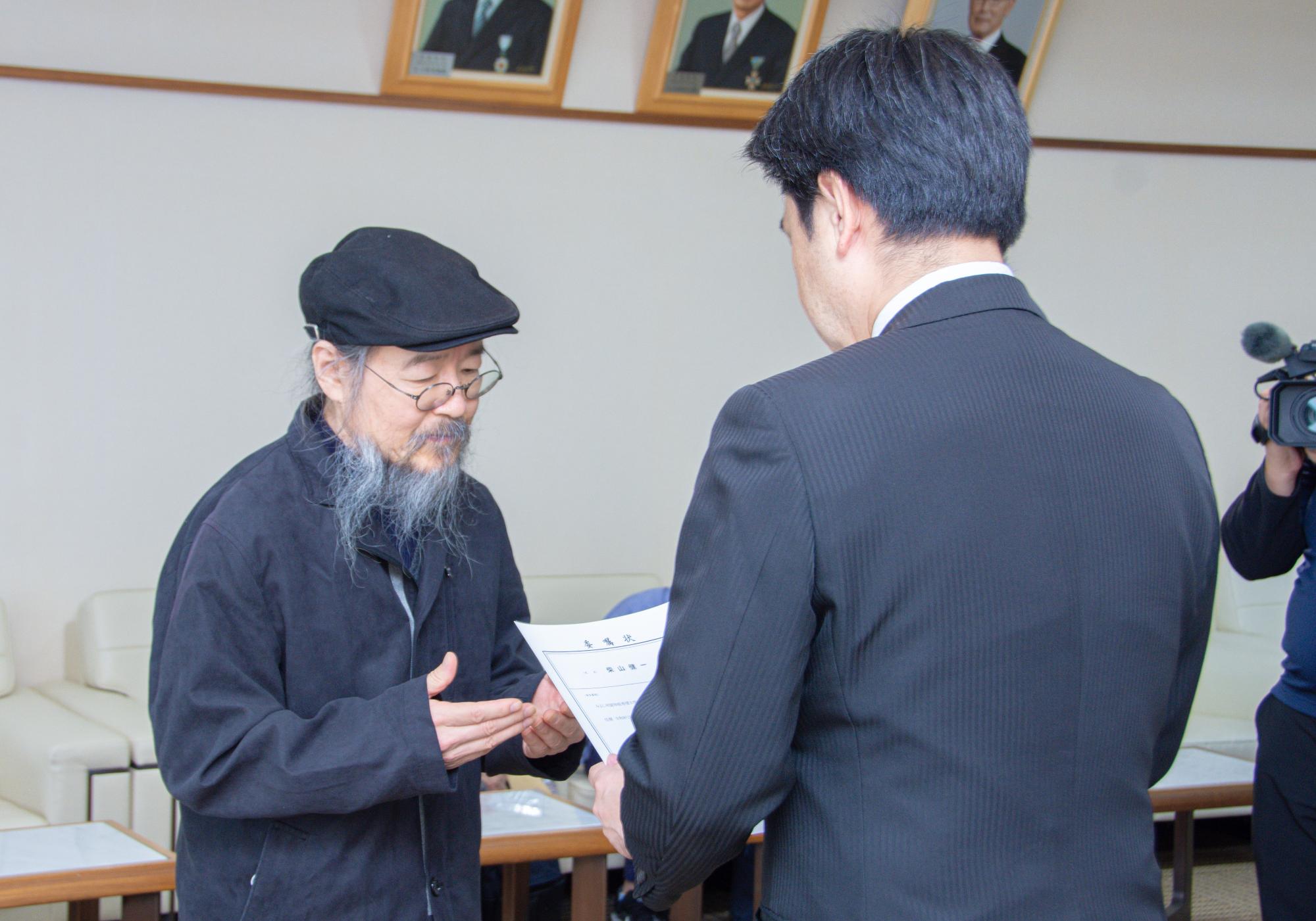 小山市長から柴山さんへ委嘱状を渡す様子