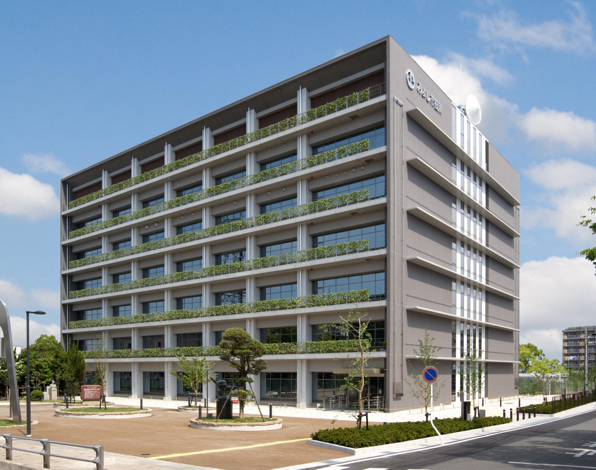 7階建てでグレーの外壁をしたみよし市役所の外観を写した写真