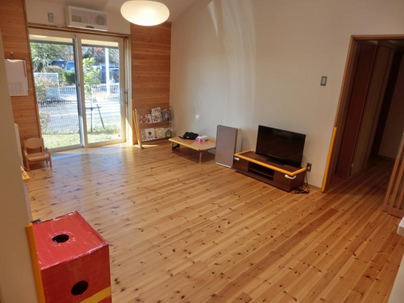 フローリングの部屋本棚やテレビが設置された部屋の写真