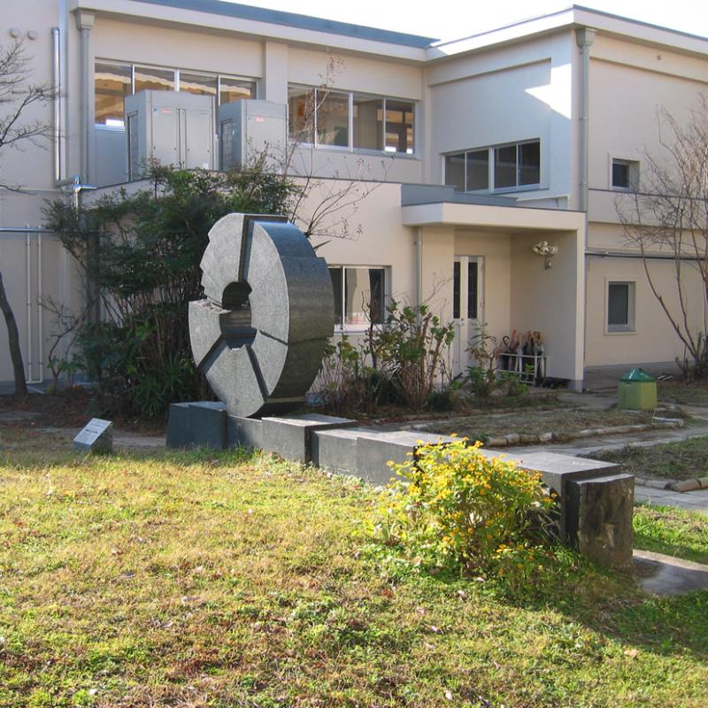 北部小学校の校舎の前に設置された円に空洞があり割れはだを見せた作品の写真