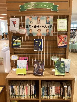 1階ティーンズと書かれ本棚の上や吊るし棚に本が飾られ紹介されている写真