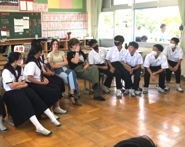 コロンバス市から来た女子高校生と男子高校生が中央に座り、両側に三好中学校の生徒たちが座り歓迎会が行われている様子の写真