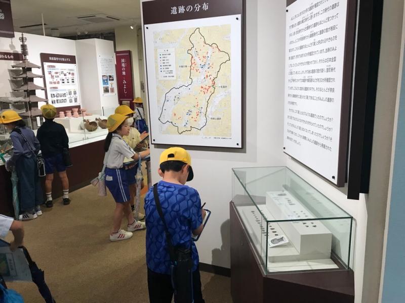 大きな地図や案内文を見ている児童たちの写真