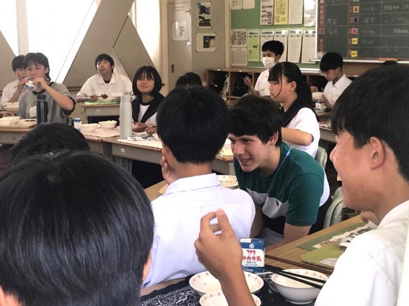 コロンバス市から来た男子高校生が横に座っている男子中学生に話しかけている様子の写真