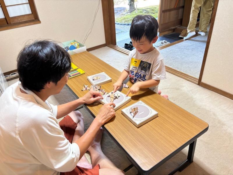 紙相撲をして遊んでいる親子の写真