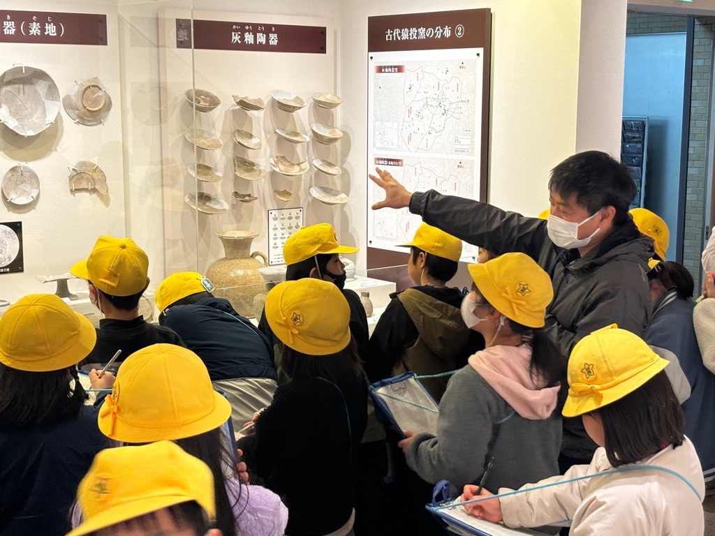 資料の前に立ってメモをとっている児童たちの写真
