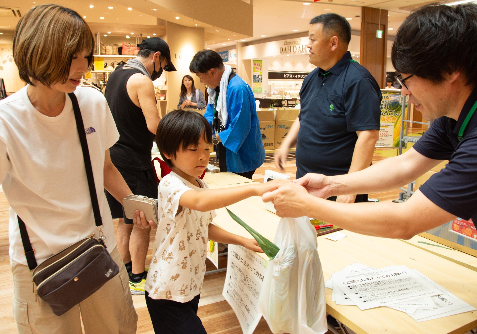 トウモロコシを購入する親子