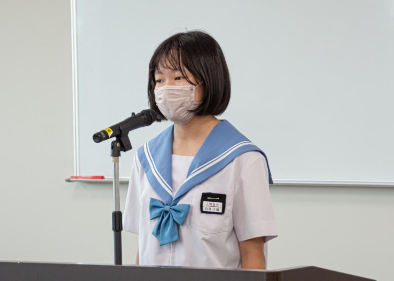 女子中学生が演壇に立ち、マイクの前で話をしている写真