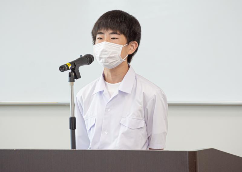 男子中学生が演壇に立ち、マイクの前で話をしている写真