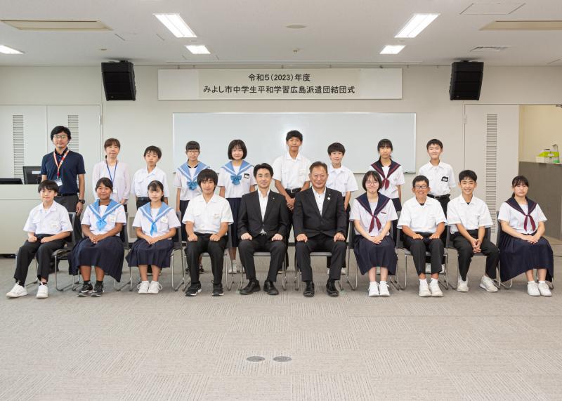 小山祐市長と増岡潤一郎さんを中心に中学生たちが横に2列に並んで正面を向いている写真
