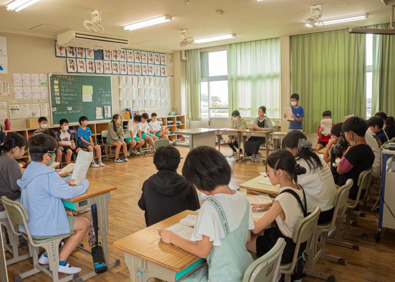 机を法廷のように並べた教室で生徒達によって模擬裁判が行われている様子の写真