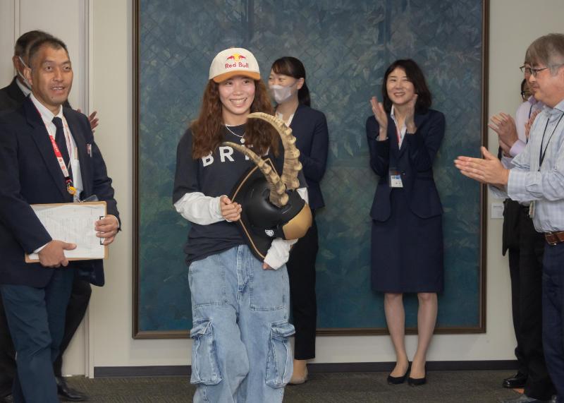 トロフィーを持って笑顔で市役所を後にする深田さん