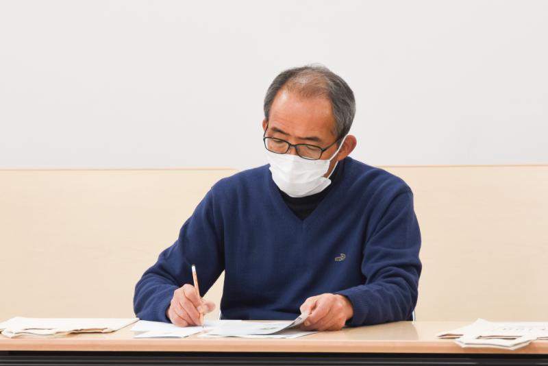 野場義尊さんの説明を熱心にメモしている男性の写真