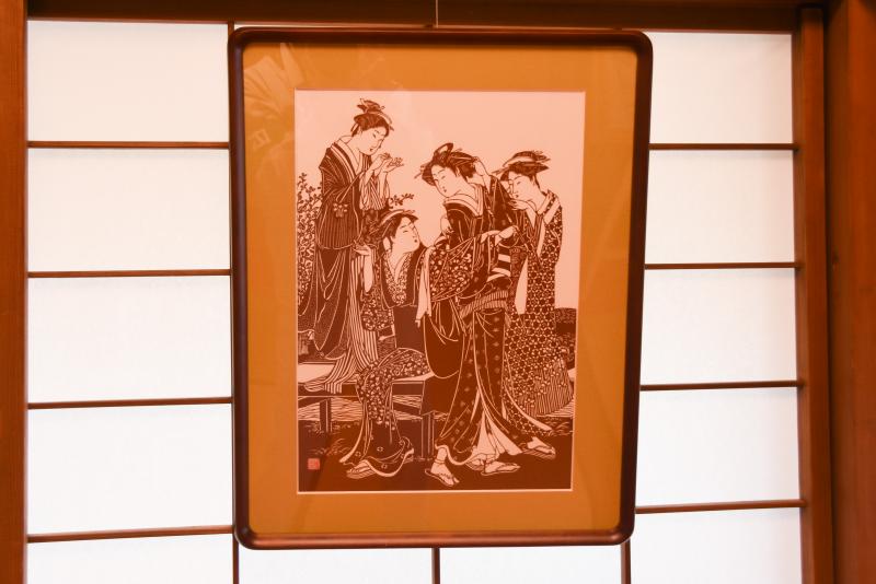 切り絵で作られた浮世絵の作品が額に入れられて障子に掛けられている写真