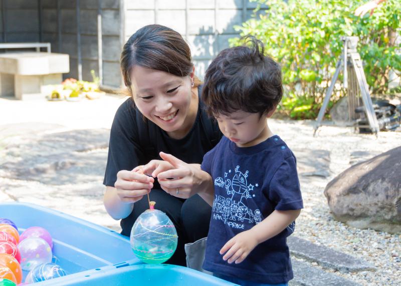 風船釣りで取った風船を男の子の手に付けようとしているお母さんの写真