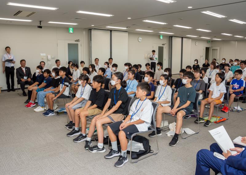児童達が並べられている椅子に座り話を聞いている写真