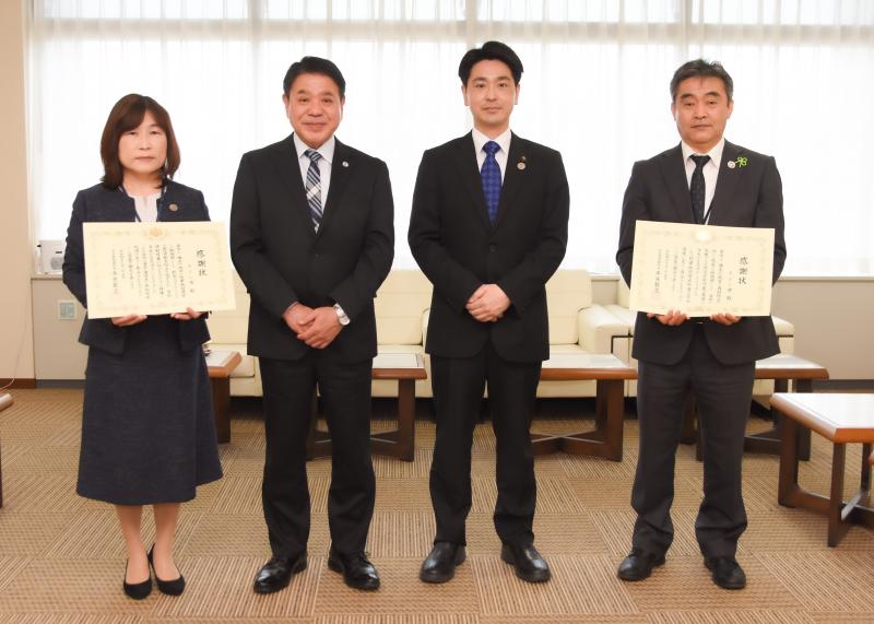 左からに賞状を持った女性、男性と市長、右端に賞状を持った男性が並んでいる贈呈式での写真