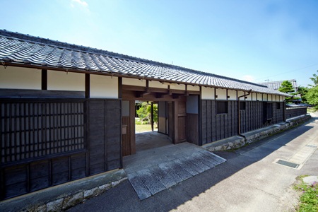 本瓦葺きで横に長く続いている石川家住宅の長屋門の写真