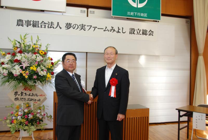 久野市長と萩野会長ががっちり握手