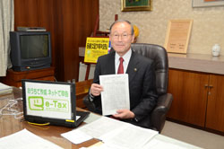 写真：作成した書類を見せて笑顔の市長