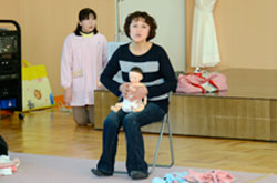 【写真】人形を使ってマッサージのコツを説明する澤田さん