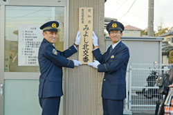 【写真】標札を掲出する渡邊署長と職員