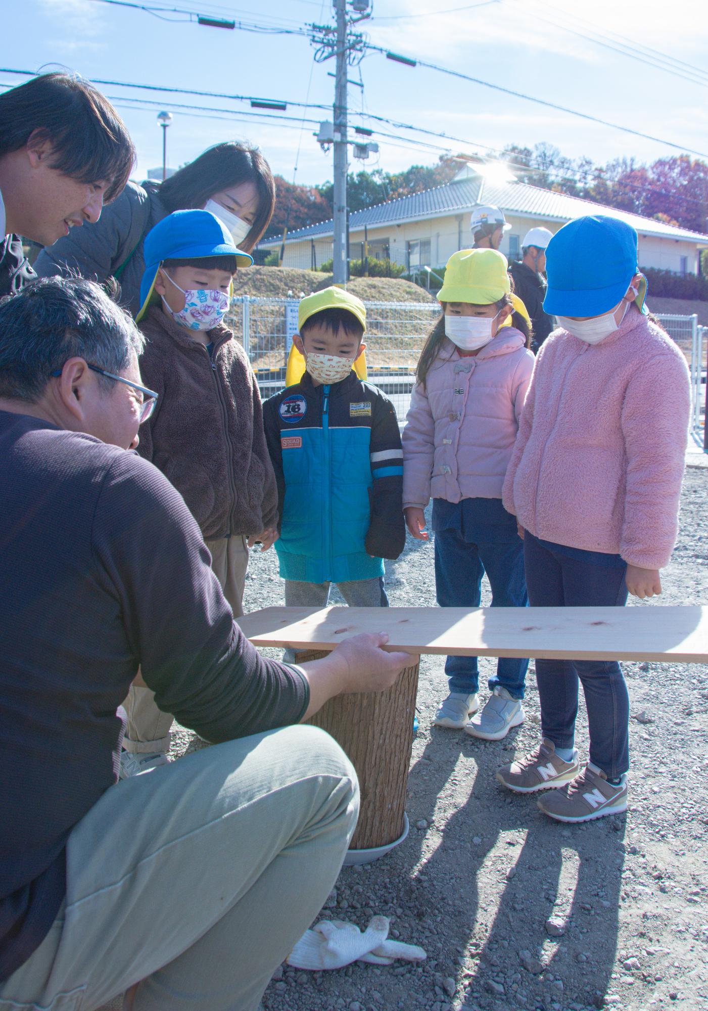 舗装作業の説明を受ける園児たち