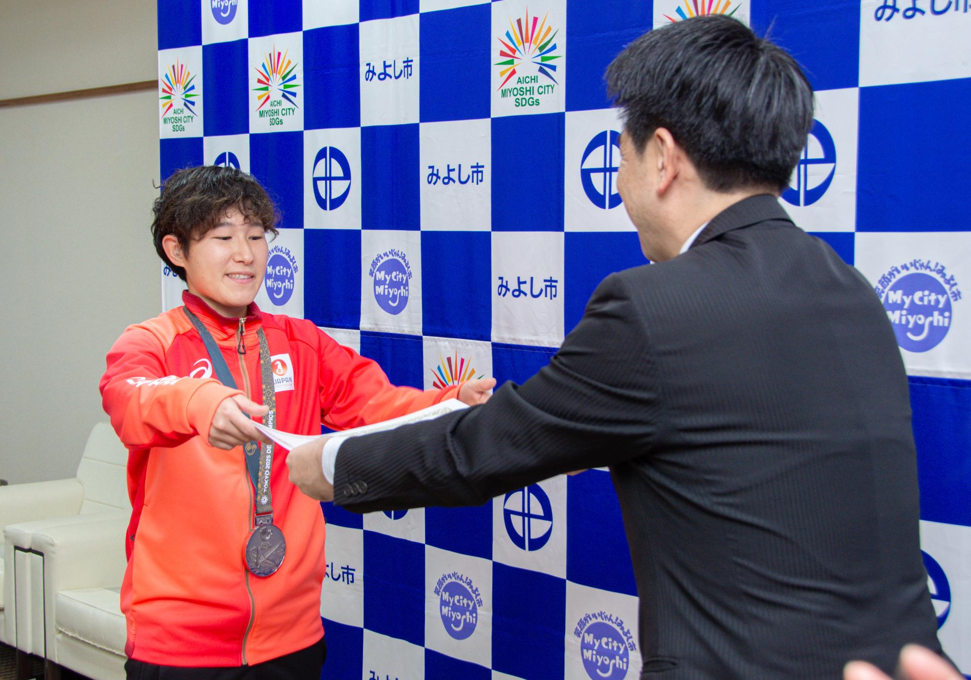 小山市長が阿部さんに栄光賞を渡す場面