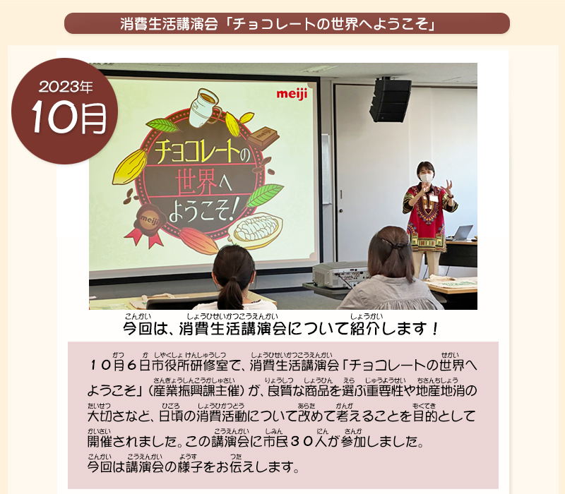 チョコレートの世界へようこそ！と書かれたスクリーンの横で女性がマイクを持って話をしている写真
