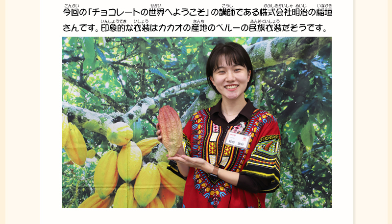 ペルーの民族衣装を着て、赤く熟れたカカオを手に持って微笑んでいる稲垣さんの写真