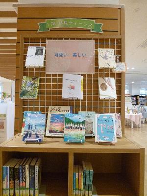 1階ティーンズと書かれ本棚の上や吊るし棚に本が飾られ紹介されている写真