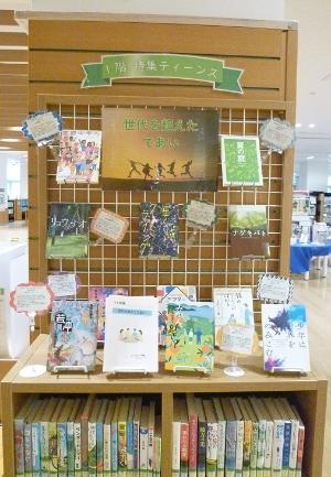 1階ティーンズと書かれ本棚の上や吊るし棚に本が飾られ紹介されている写真