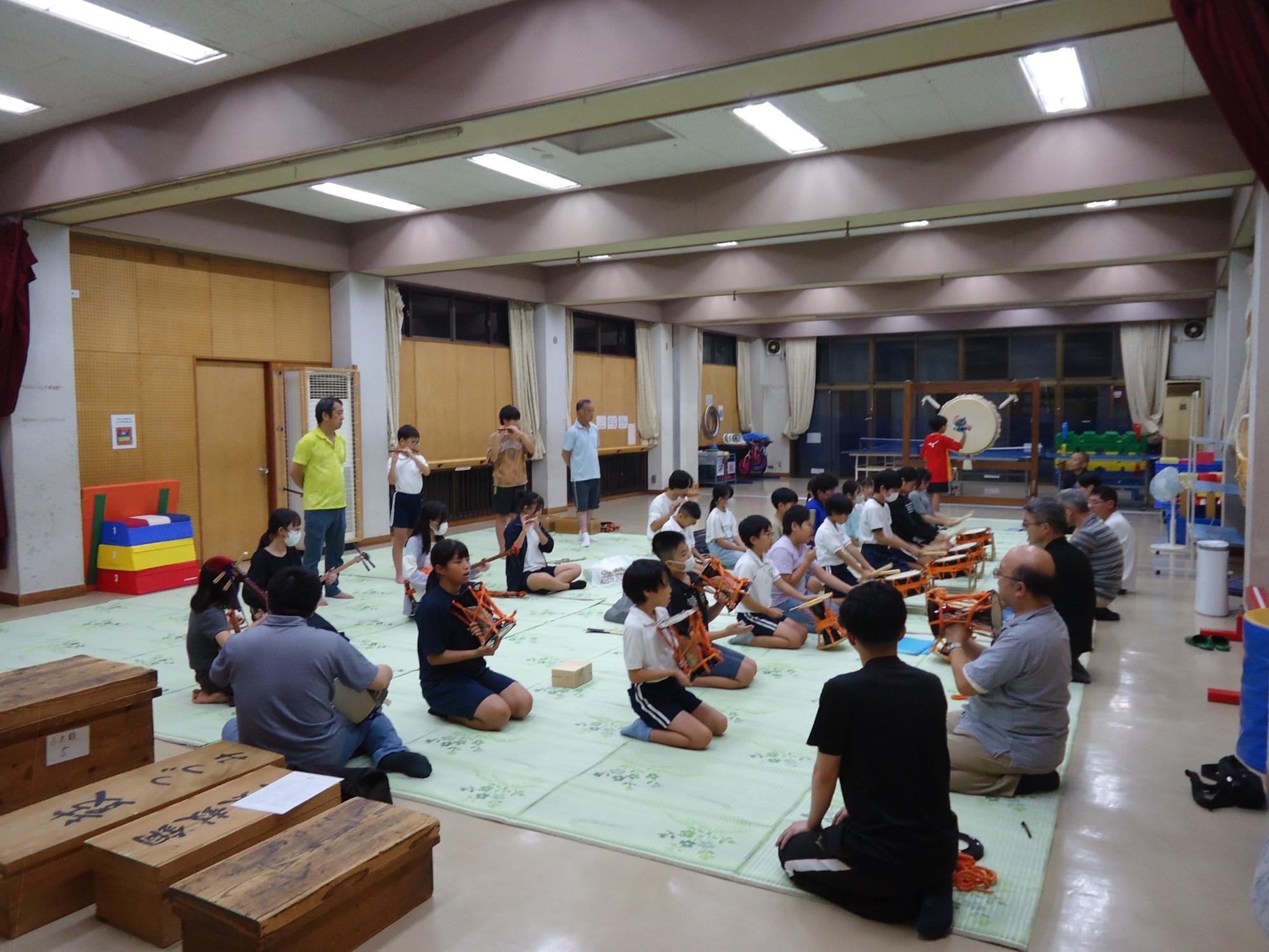 ホールで保存会の皆さんが向き合って演奏の練習をしている写真