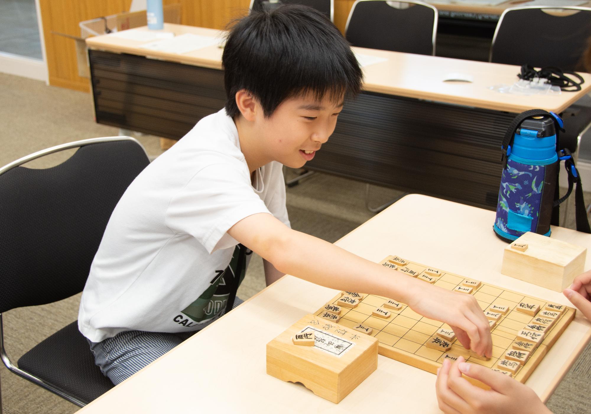 将棋体験で将棋を打つこども