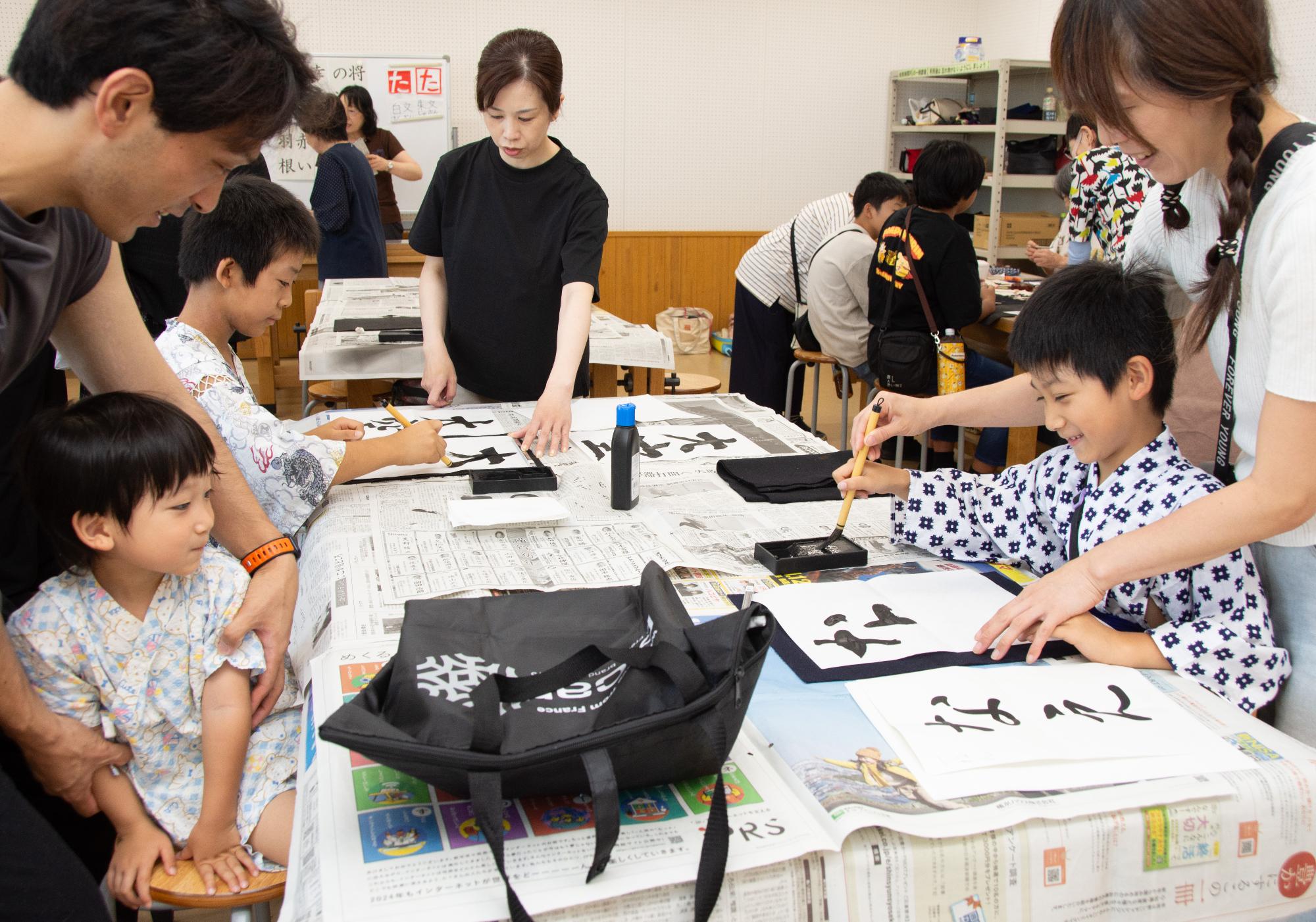 夏休みの宿題をここで済まそう。書道体験をするこどもたち
