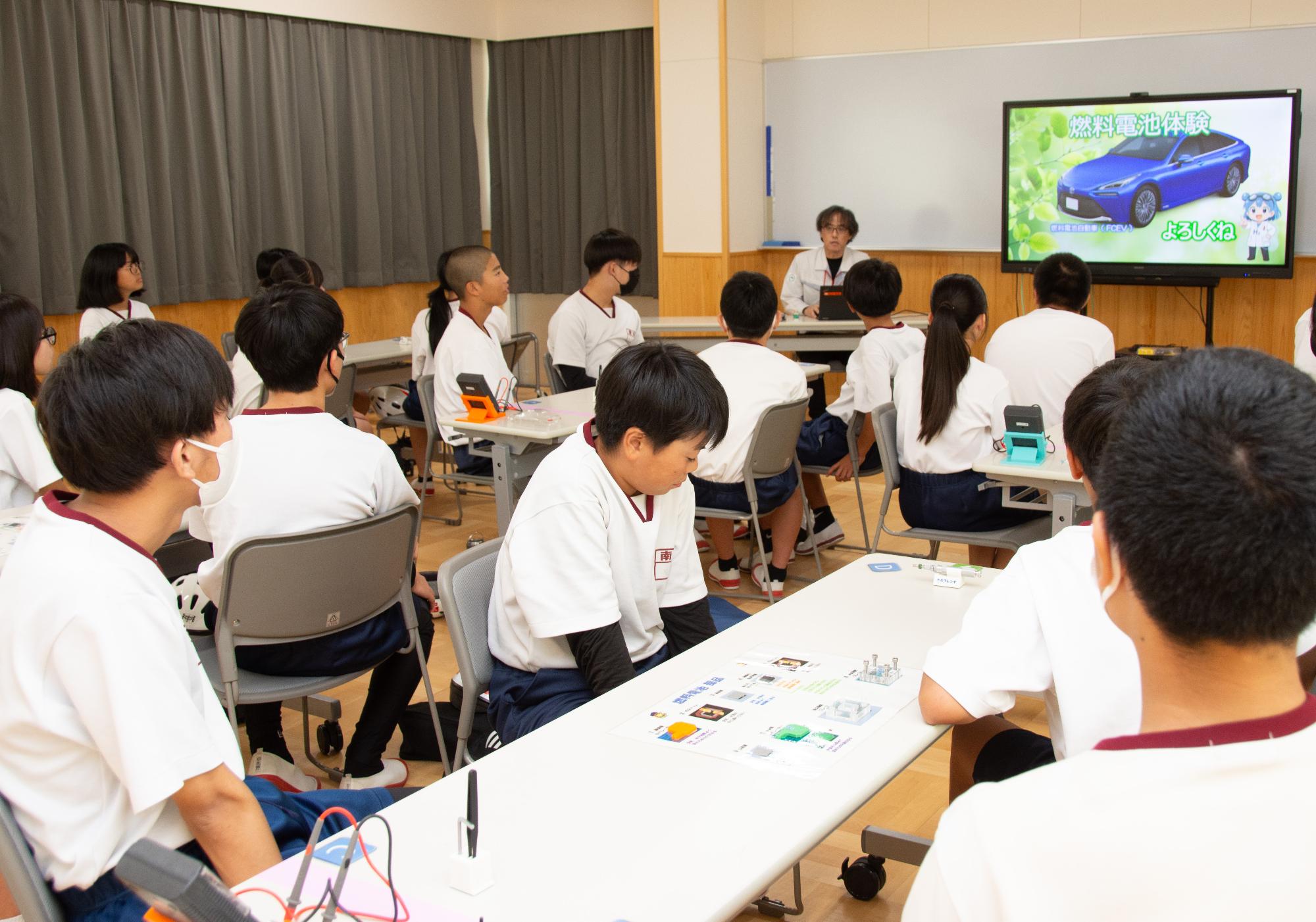 水素の仕組みの説明を受ける生徒たち