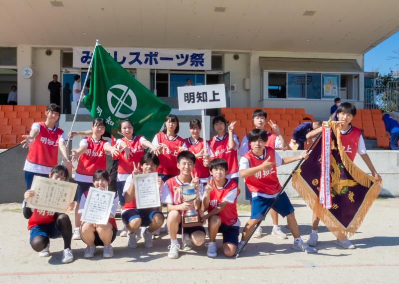 総合優勝した明知上行政区の選手の皆さんが優勝旗とトロフィー、賞状をもって撮影した集合写真