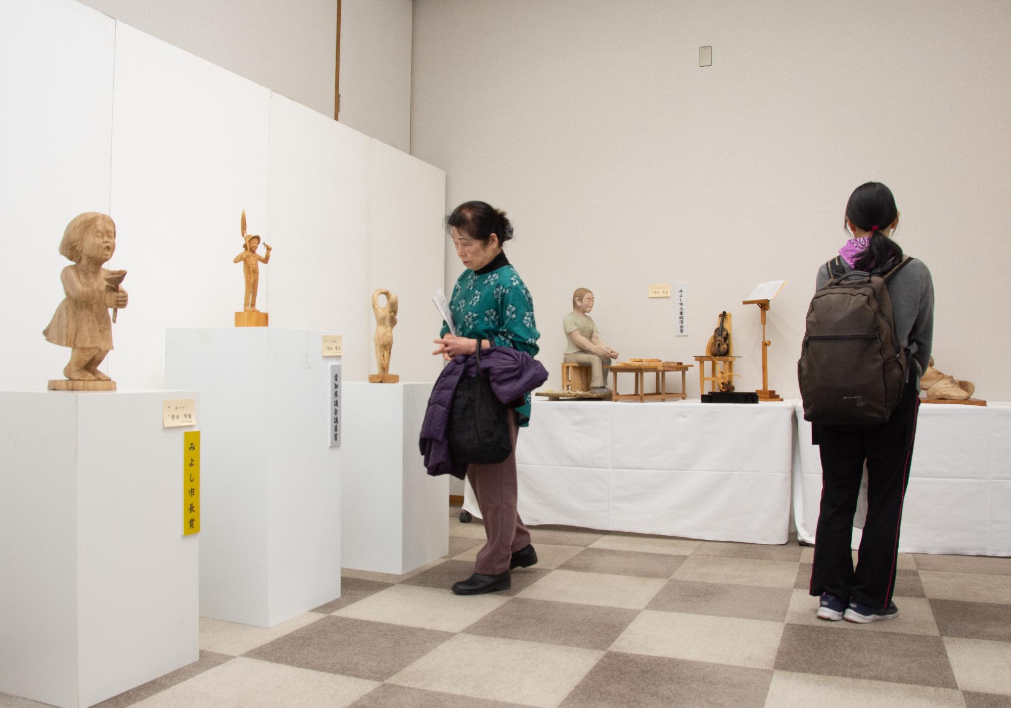 美術展の陶芸作品を見る人たち