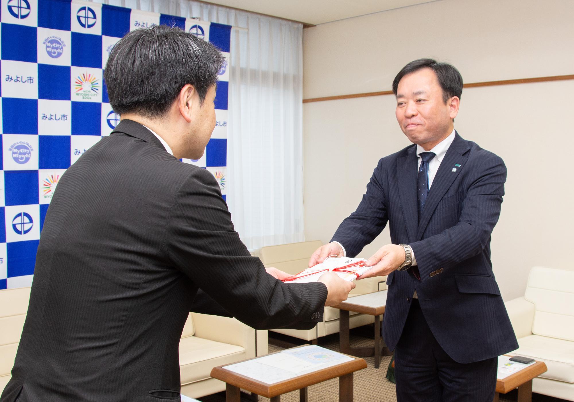 手旗の目録を市長に渡す武藤支店長