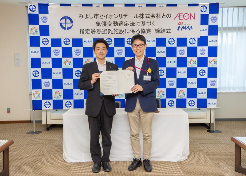 小山市長（左）と伊藤店長（右）が協定書をもって並んで立っている写真